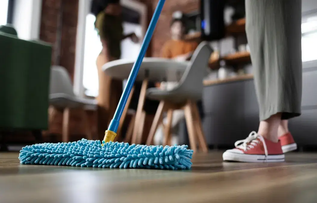 Close-up of a person mopping the floor in a modern home.