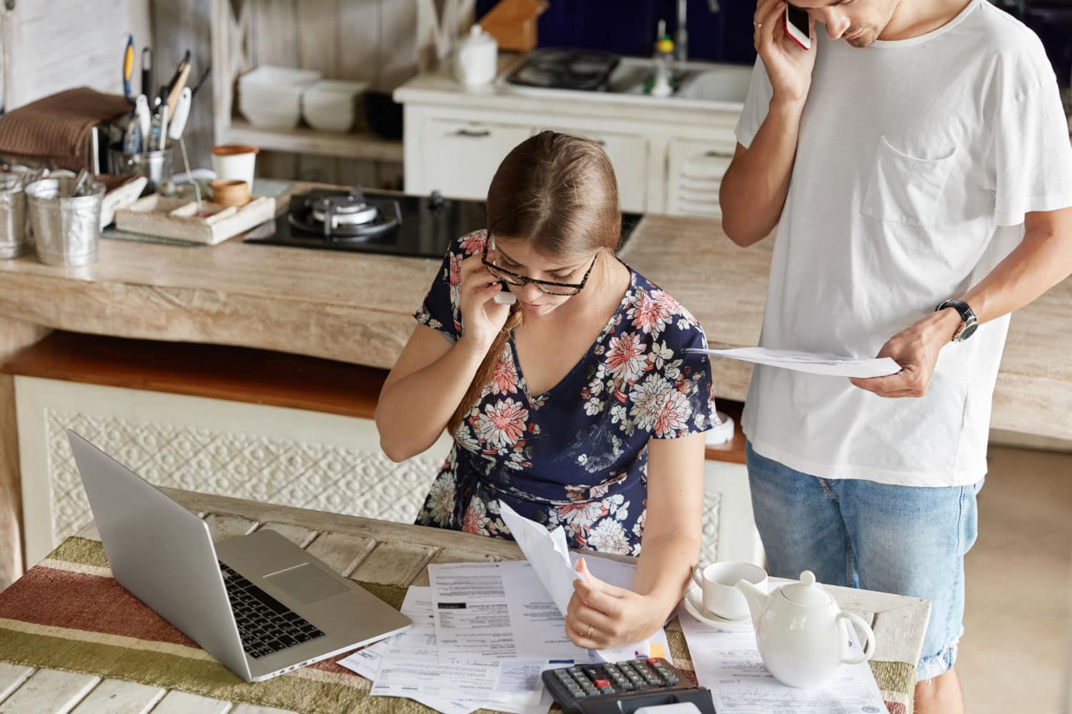 Couple reviewing bills and documents, discussing house cleaning cost.