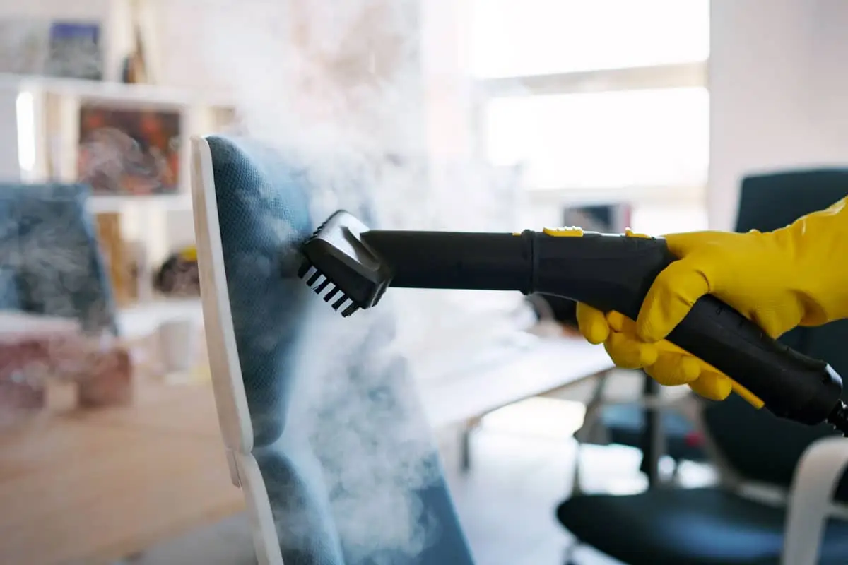 Professional office cleaning service cleaning an office chair for deep sanitization.