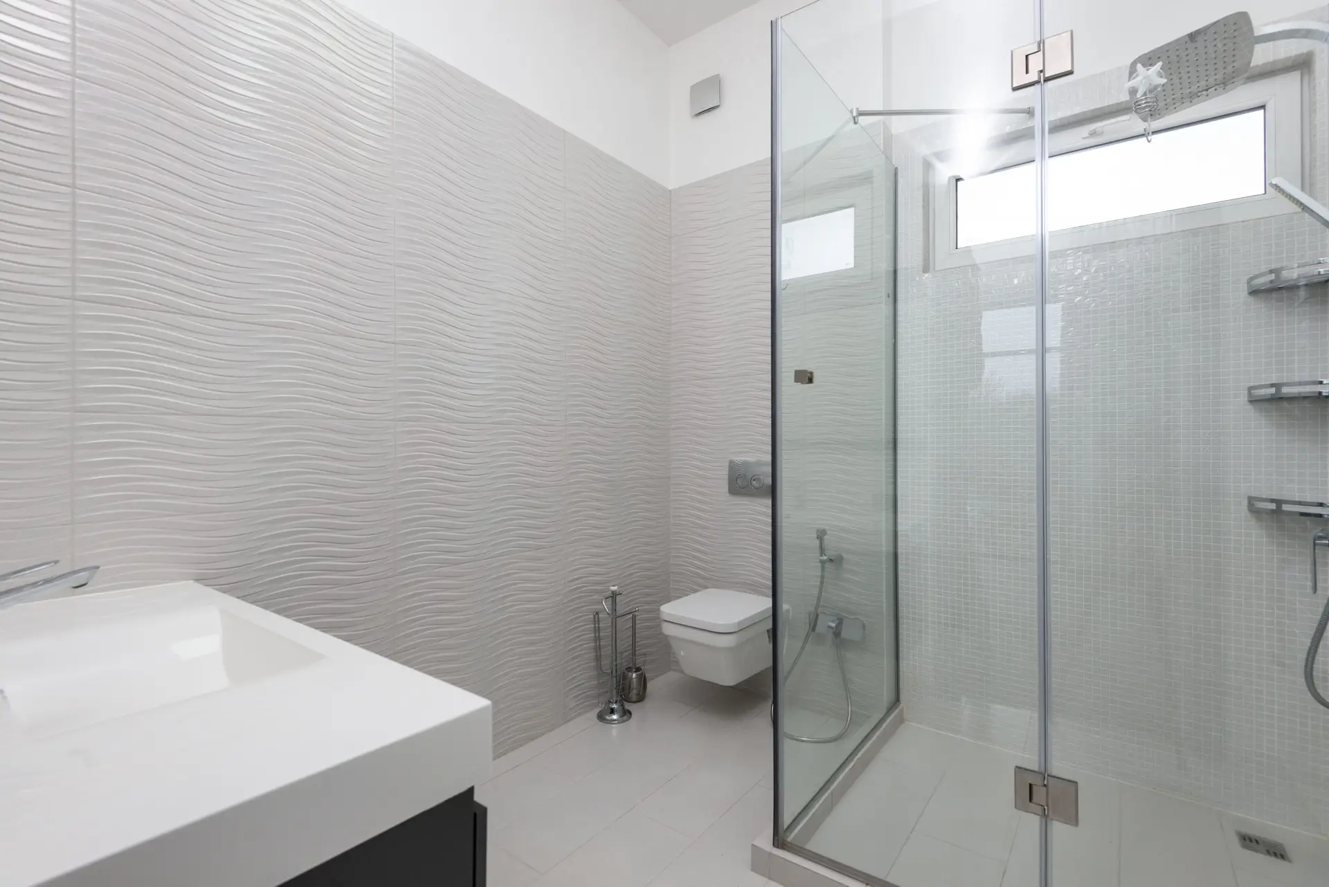 Bright modern bathroom with glass shower in a Plano TX home cleaned before school starts