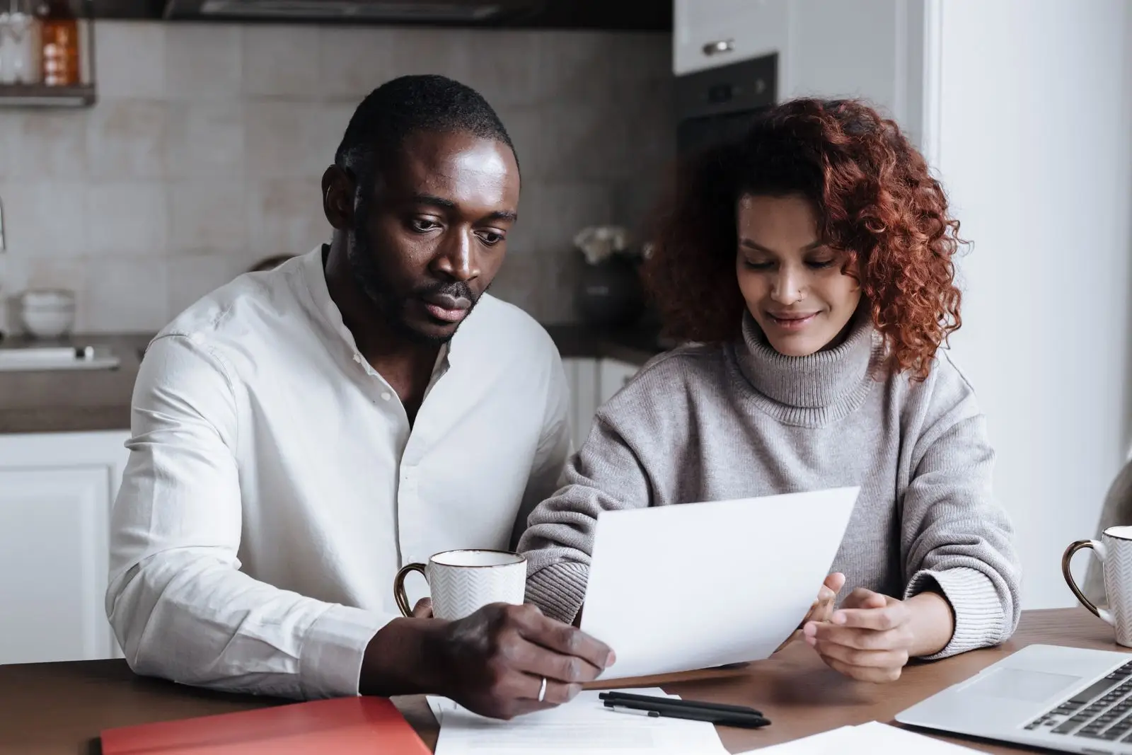 Couple reviewing and comparing two house cleaning quotes at a bright kitchen table in Frisco, Texas