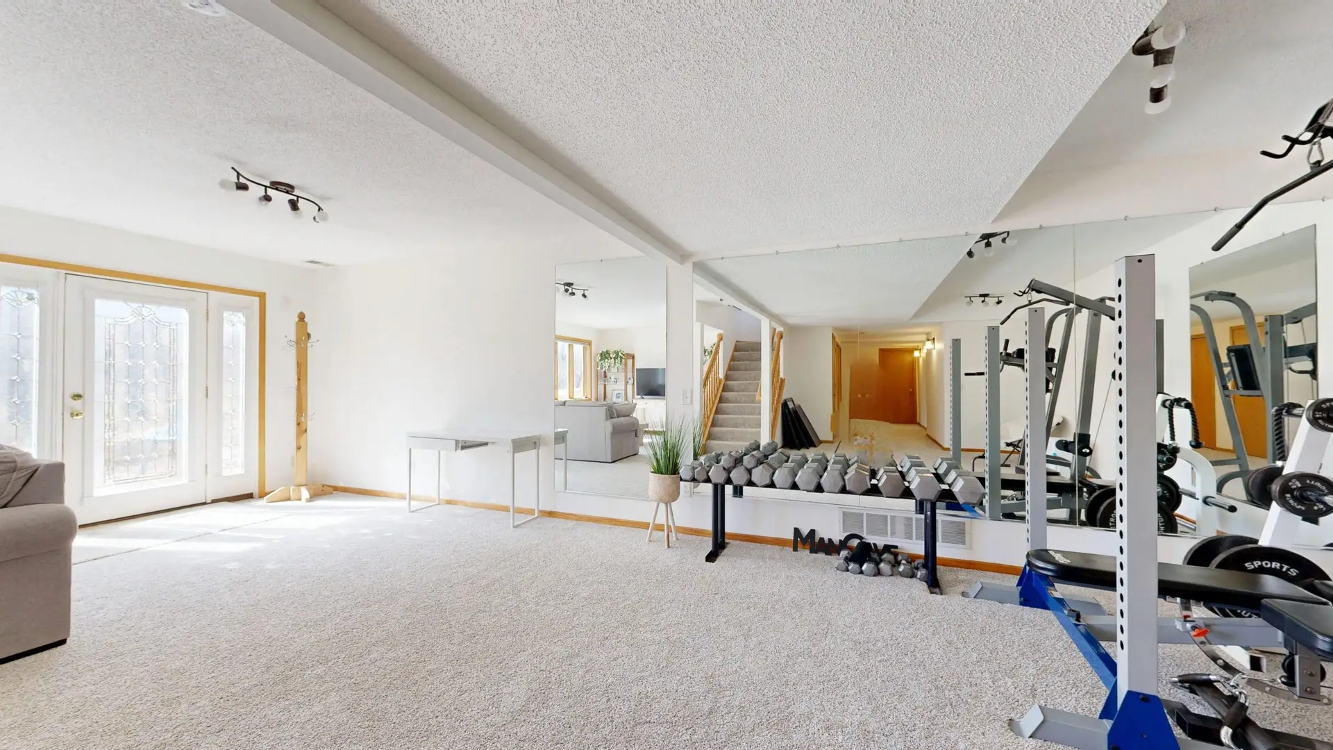 Bright white home gym with weight equipment in a bonus room