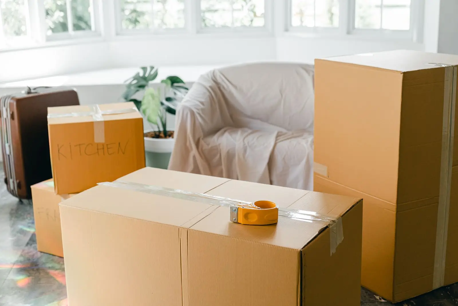 Bright empty living room with packed moving boxes during a move out and move in week in McKinney