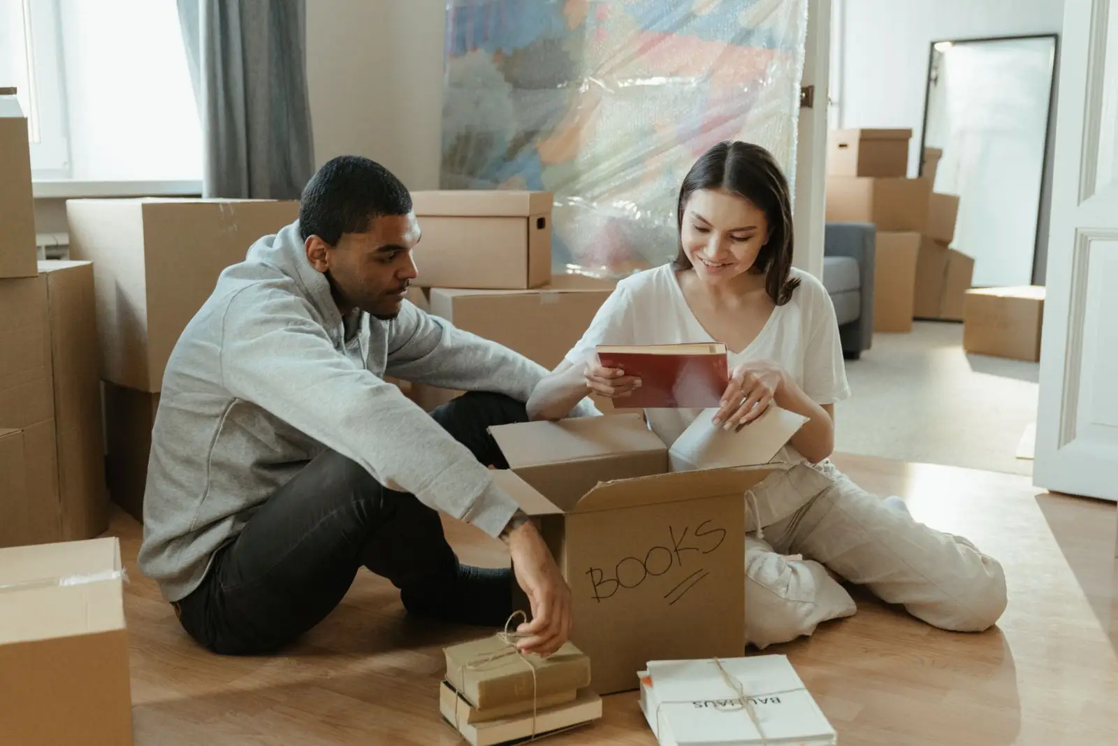 Couple unpacking boxes in a bright new home in Celina TX before the settling in cleaning