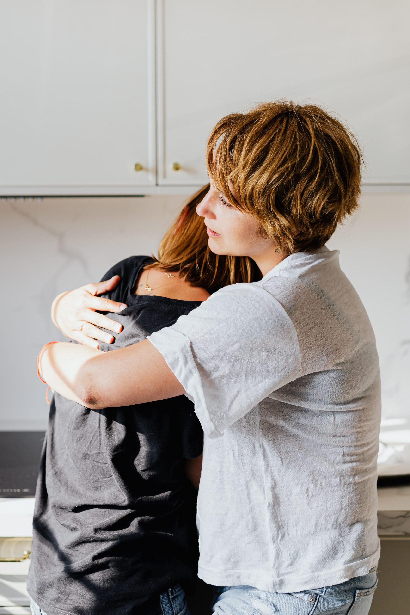 Two women embracing in support during breast cancer treatment