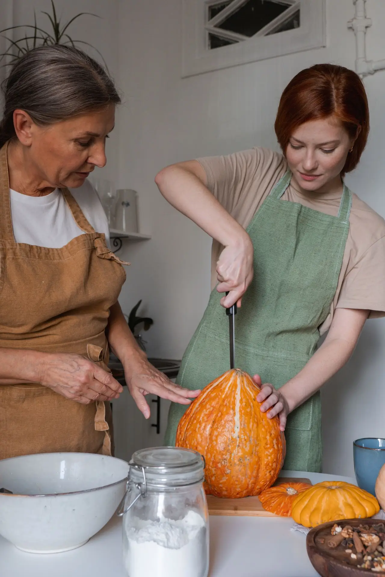Two people cutting a pumpkin in a bright kitchen in Celina TX